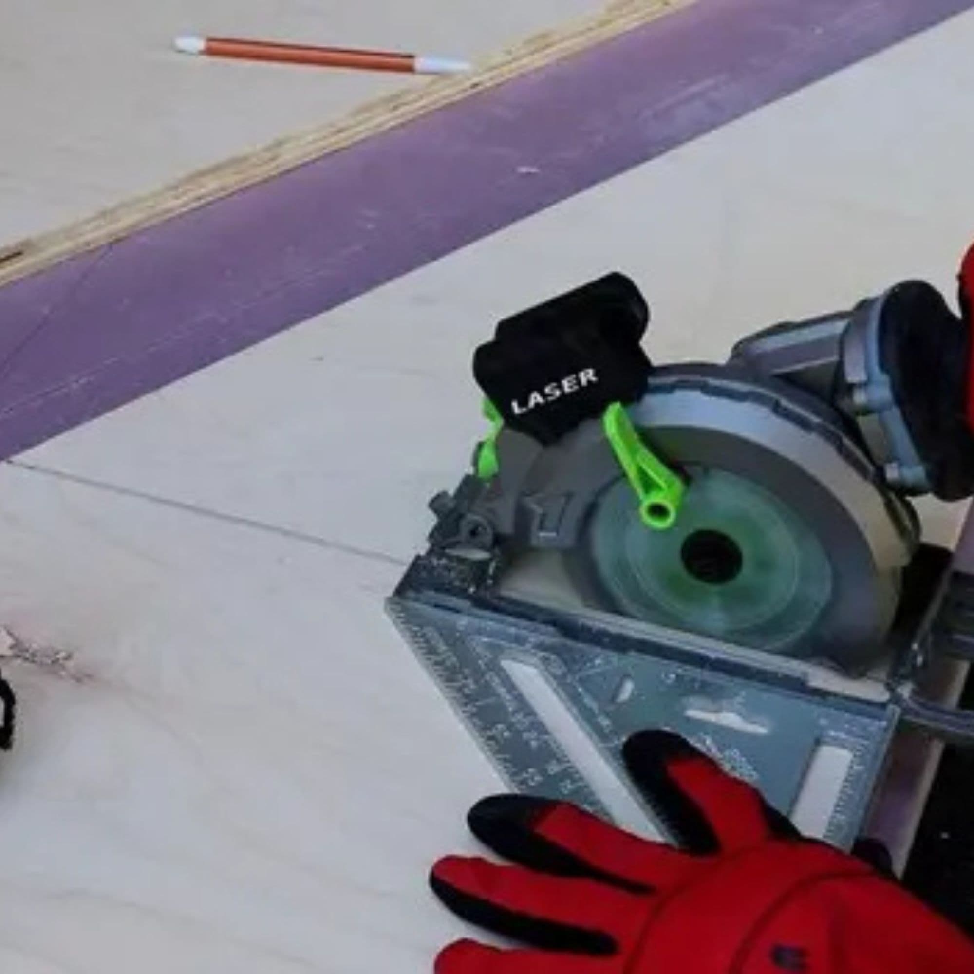 Circular saw with a laser guide cutting along a marked line in plywood