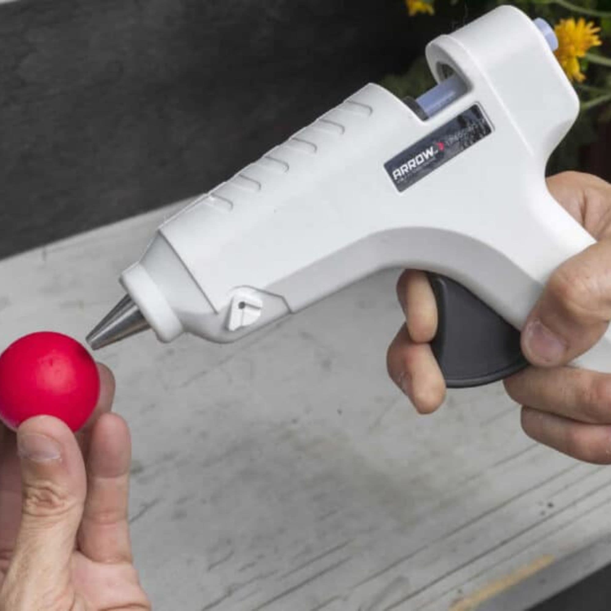 A person uses a glue gun to add glue to a spooky eyeball.