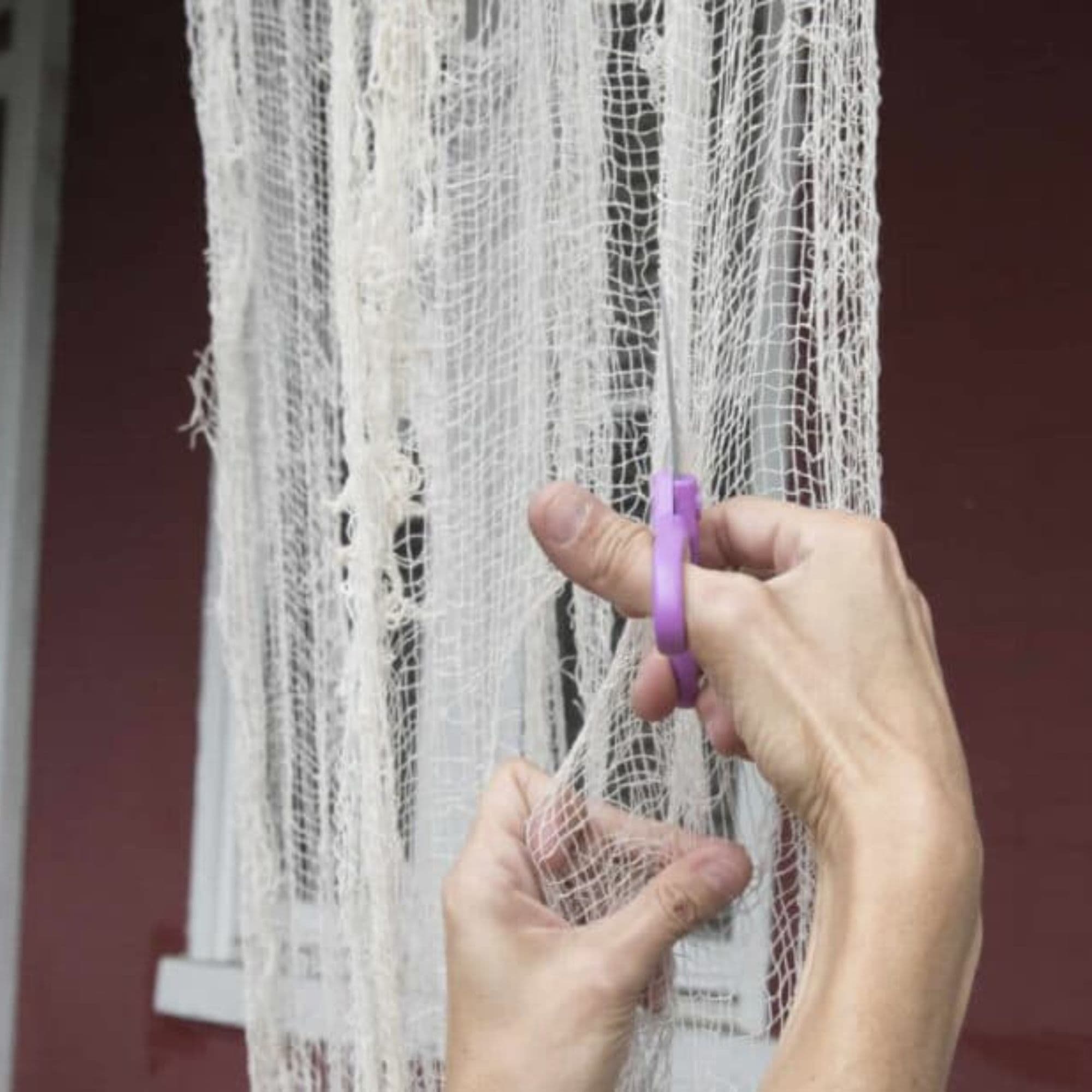 Serena cuts cheesecloth with a scissor.