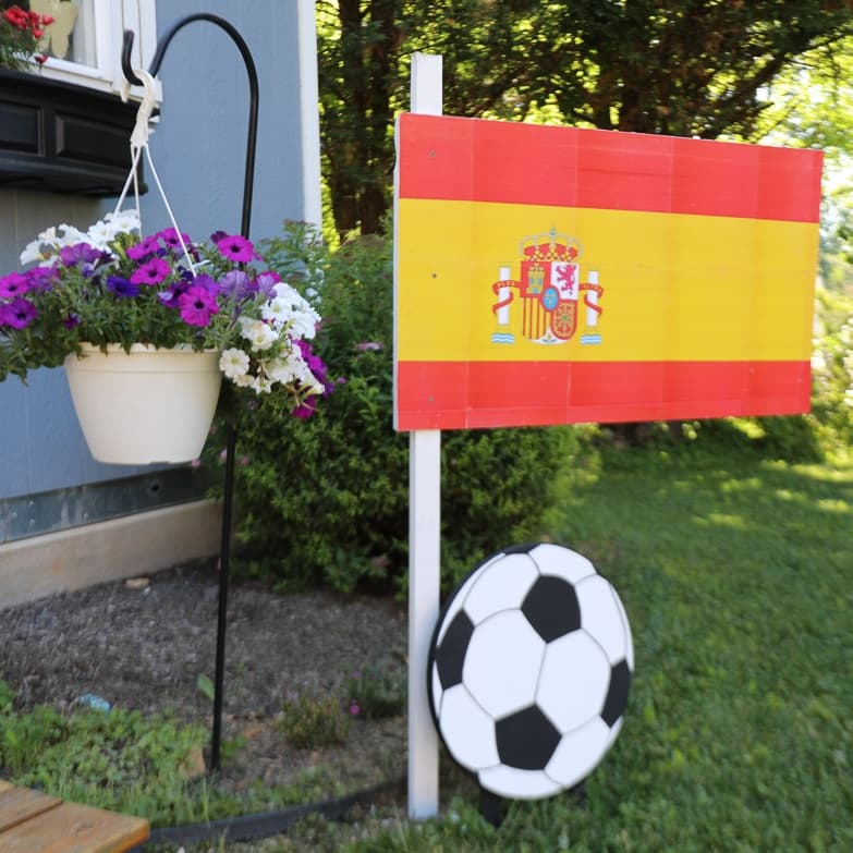 Spanish flag mounted on a wood post with flowers