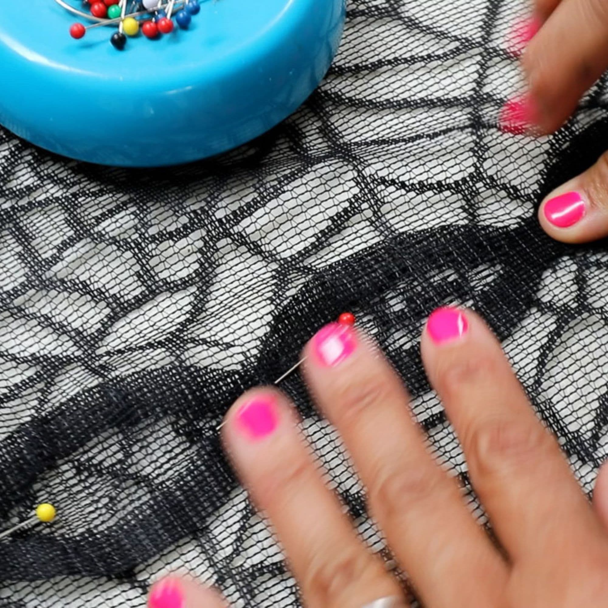 Serena is using ball headed sewing pins to pin two table runners together. Her hands and a magnetic pincushion are visible in frame.