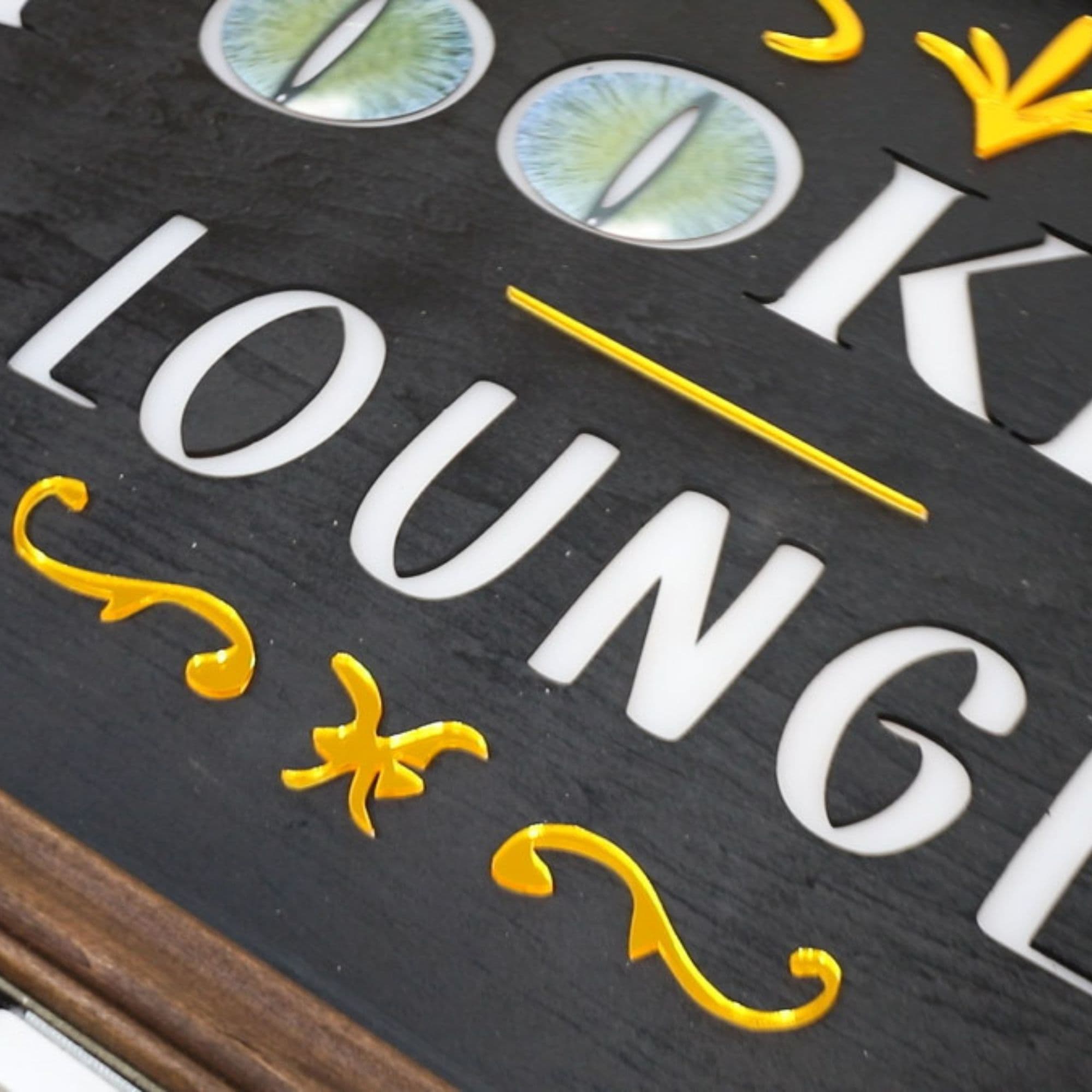 A front view of the decorated Spookeasy Lounge sign. The o's in Spookeasy are decorated with creepy cat eyes.