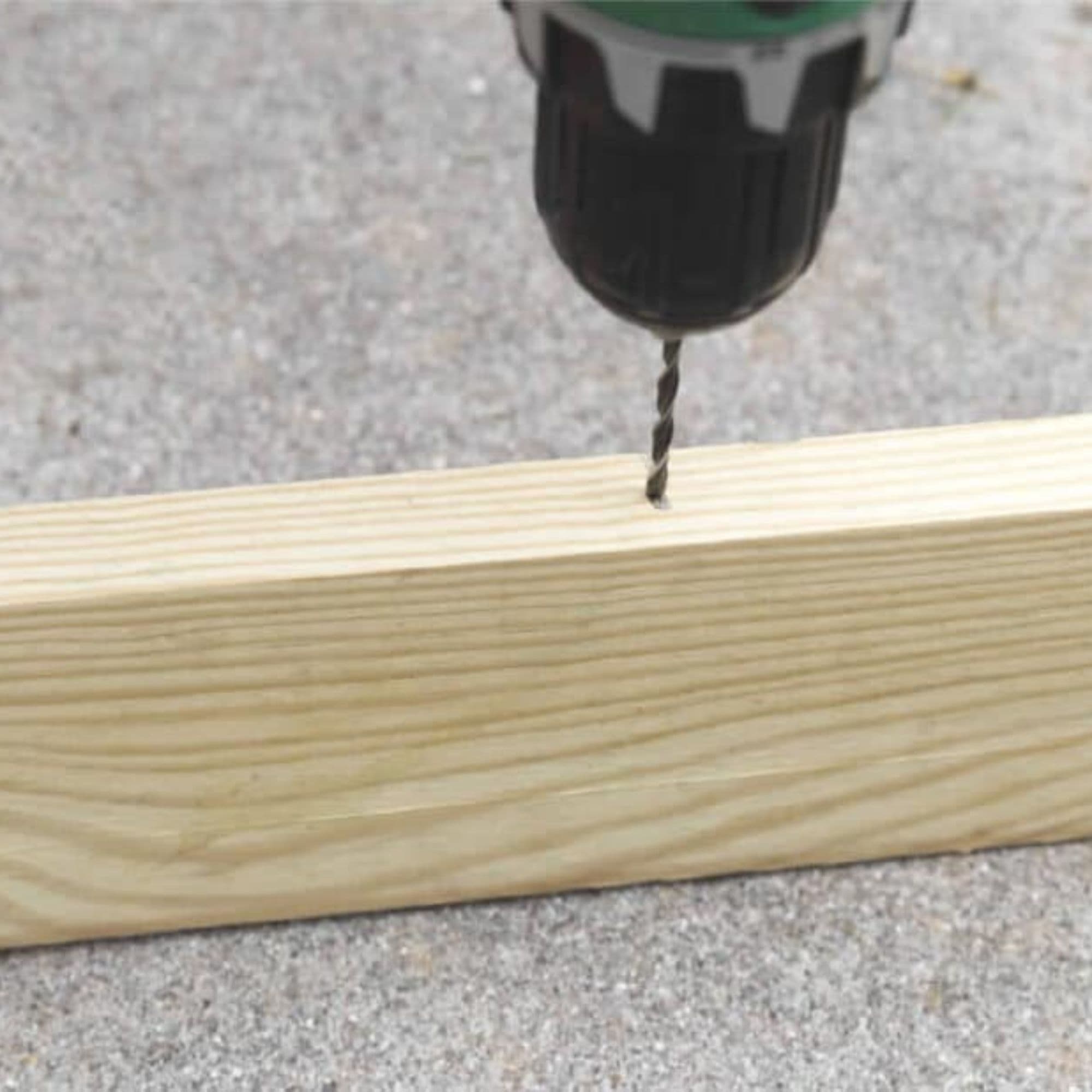Serena uses a power drill to drill into a 1x4 plank.